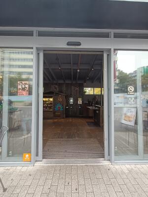 Glass door with grey, metal frame. Opens from middle.