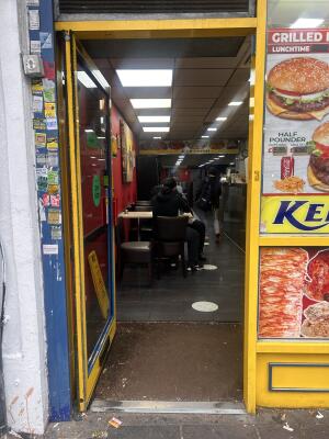 Glass door with yellow frames ahead. Push bar on right to open.