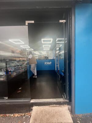 Glass door with metal handle on left. Push to open.