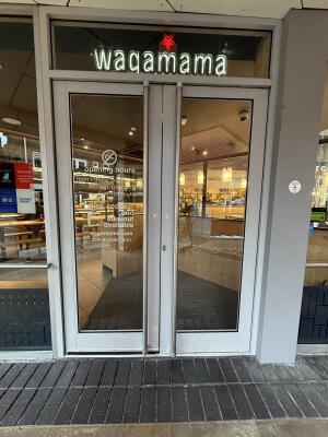 Glass doors with grey frames ahead. Pull from handle in centre to open.