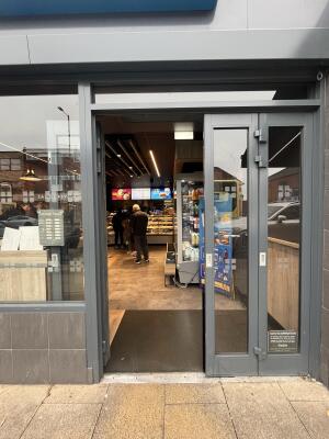 Glass double door with grey frame. Push to open.