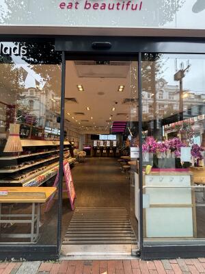 From street facing venue. Black framed sliding glass door ahead.