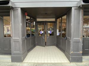 From sidewalk facing the venue. Opening to the entrance door ahead. Press button on right side.