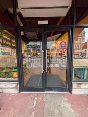 Black frame glass doors in front. Silver metal handles in center. Push to open.