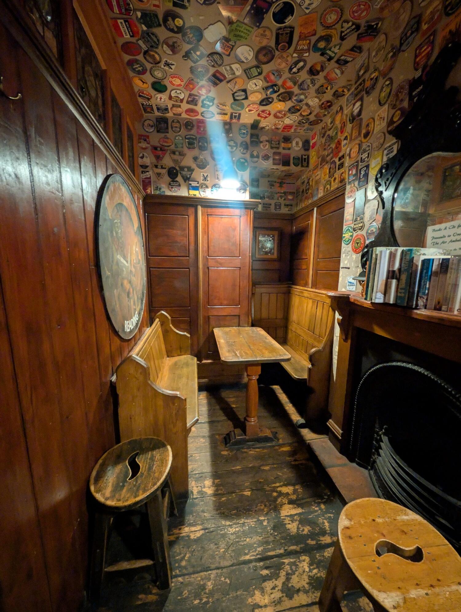 From archway facing left. Table and benches in front. Fireplace on right.
