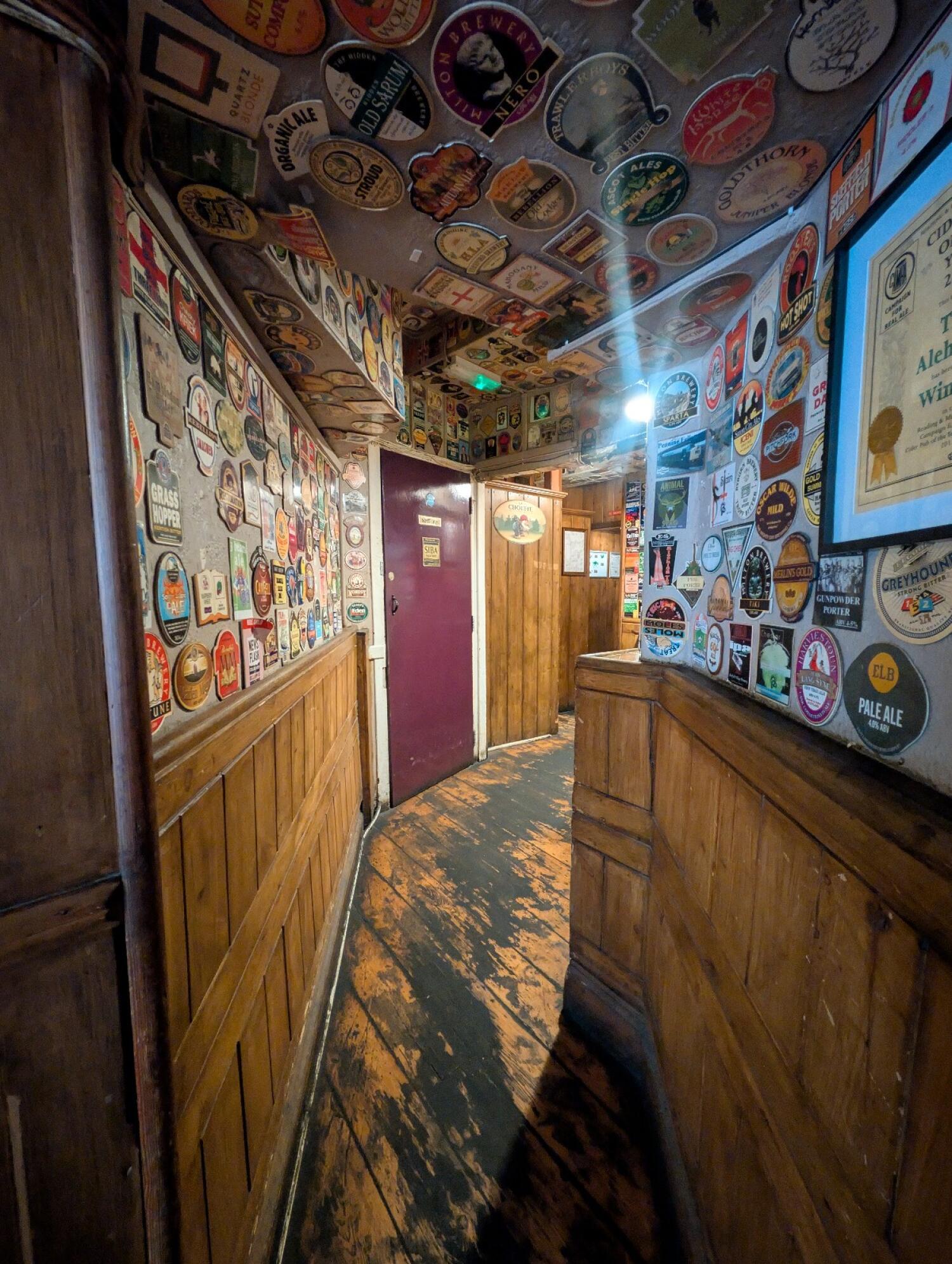 From end of corridor facing straight. Archway to more seating in front. Staff door on left back.