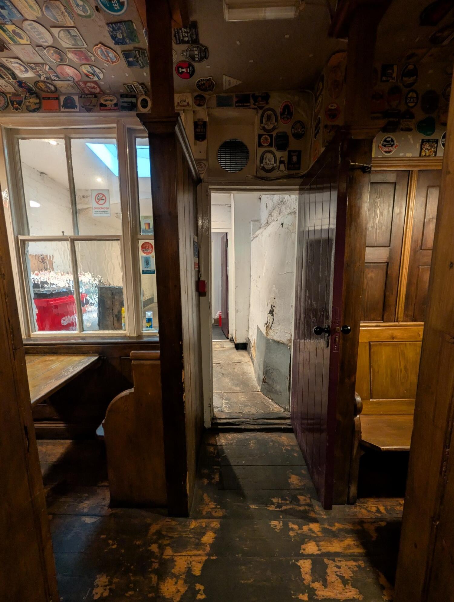 From path after chair facing straight. Wooden archways to seating on both sides. Path to bathroom at back center.