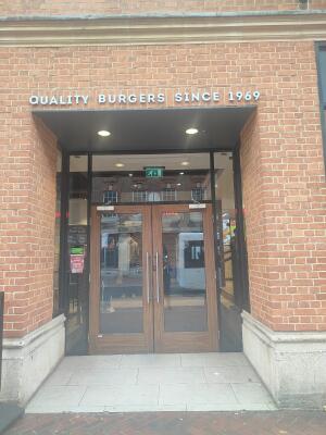 From sidewalk facing venue. Archway to entrance doors ahead.