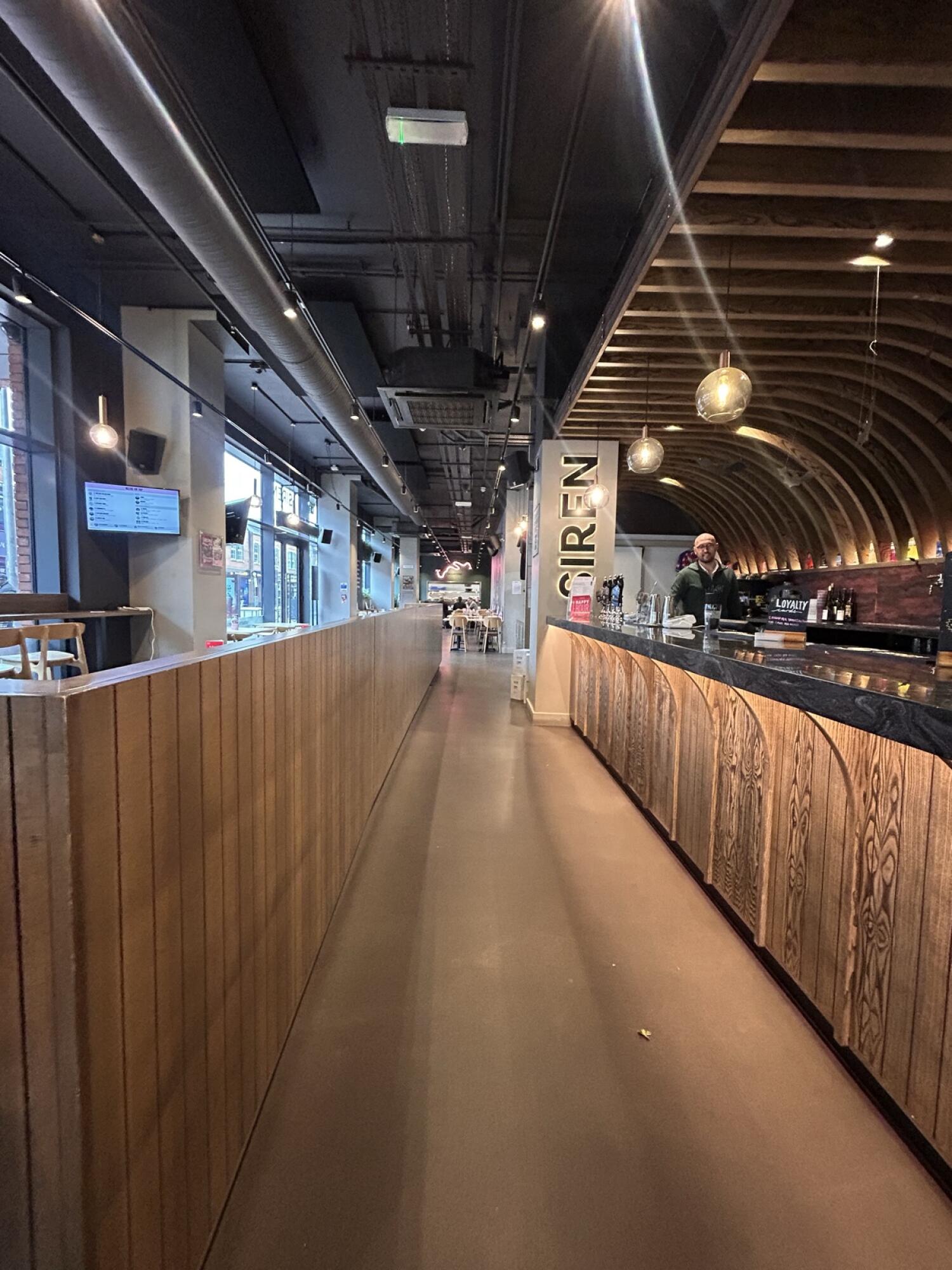 From counter facing left. Partition on left. Counter on right. Path to more seats in center.