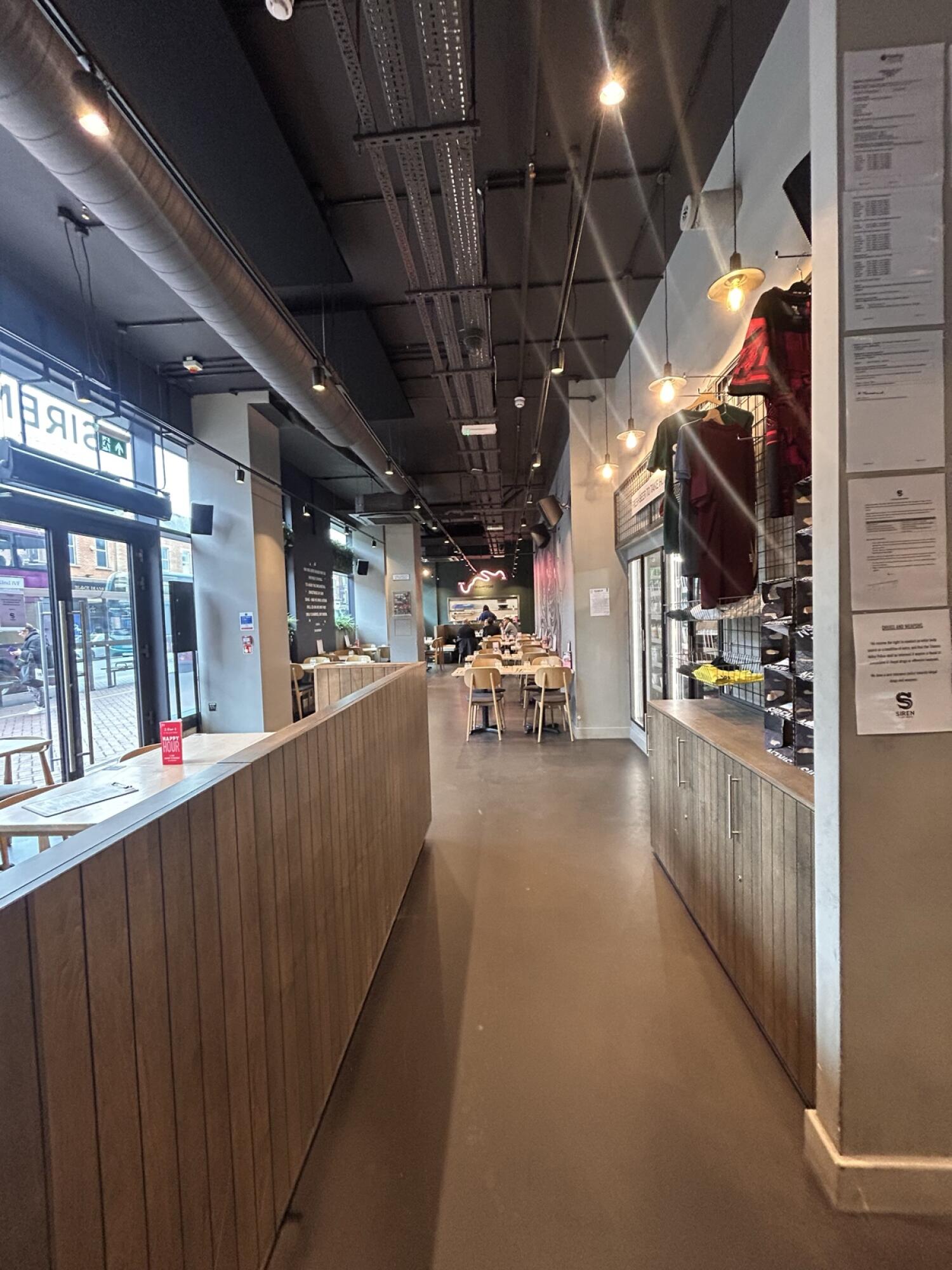 From end of counter facing straight. Partition on left. Shelf on right. Seats at back.