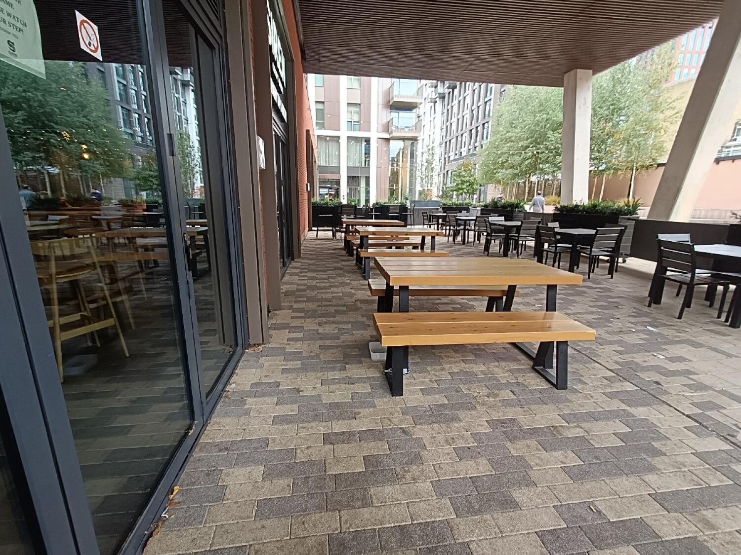 From doorway, facing left. Tables and benches along left. Tables and chairs right.