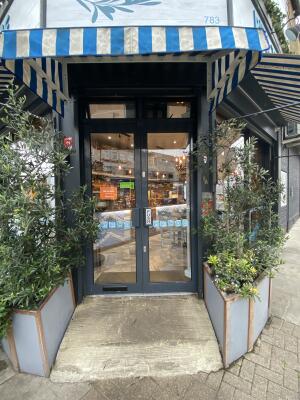 Black framed glass door. Push from centre to open. Planters on both sides of the door.