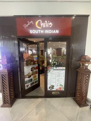 Glass doors with brown frame ahead. Push gold metal handles from centre to open.