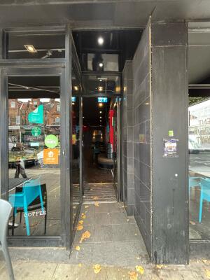 Open archway ahead to glass doors with metal frame on back. Push door to open via handle on left.