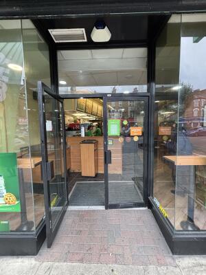 Open archway to glass doors with black frame on back. Pull doors to open via handles in centre.
