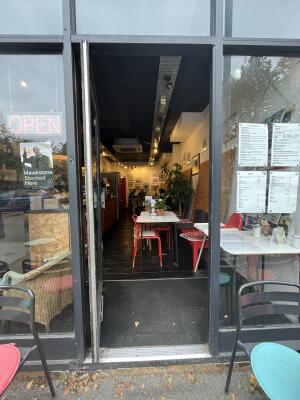 Glass door with a grey frame. Handle on right. Push to open.