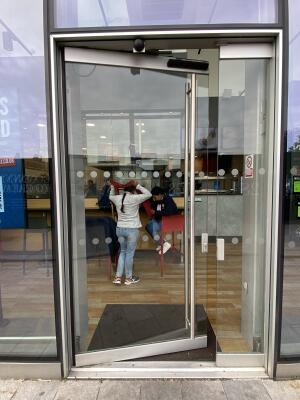Silver framed glass door. Push the silver metal long handle on right side of door to open.