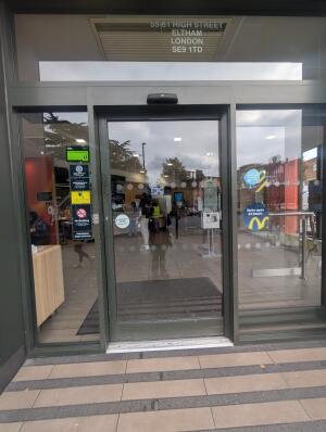 Grey frame automatic glass doors. Opens from right to left.