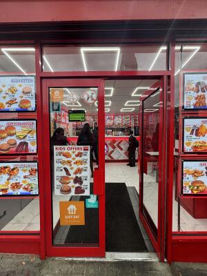 From street facing venue. Red framed glass doors ahead. Push doors in centre to open inwards.