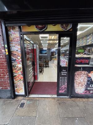 Glass door with black frame ahead. Push via handle on right to open.