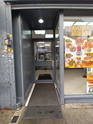 From street, facing venue. Archway ahead. Glass door with silver handle on right at back. Pull to open.