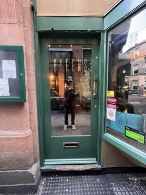 Glass door with green frame and handle on right. Push to open.