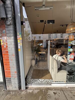 Glass door with metal handle on right. Push to open.