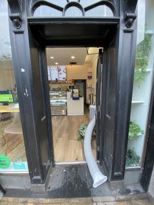 Black wooden door. Push the door from left to open.