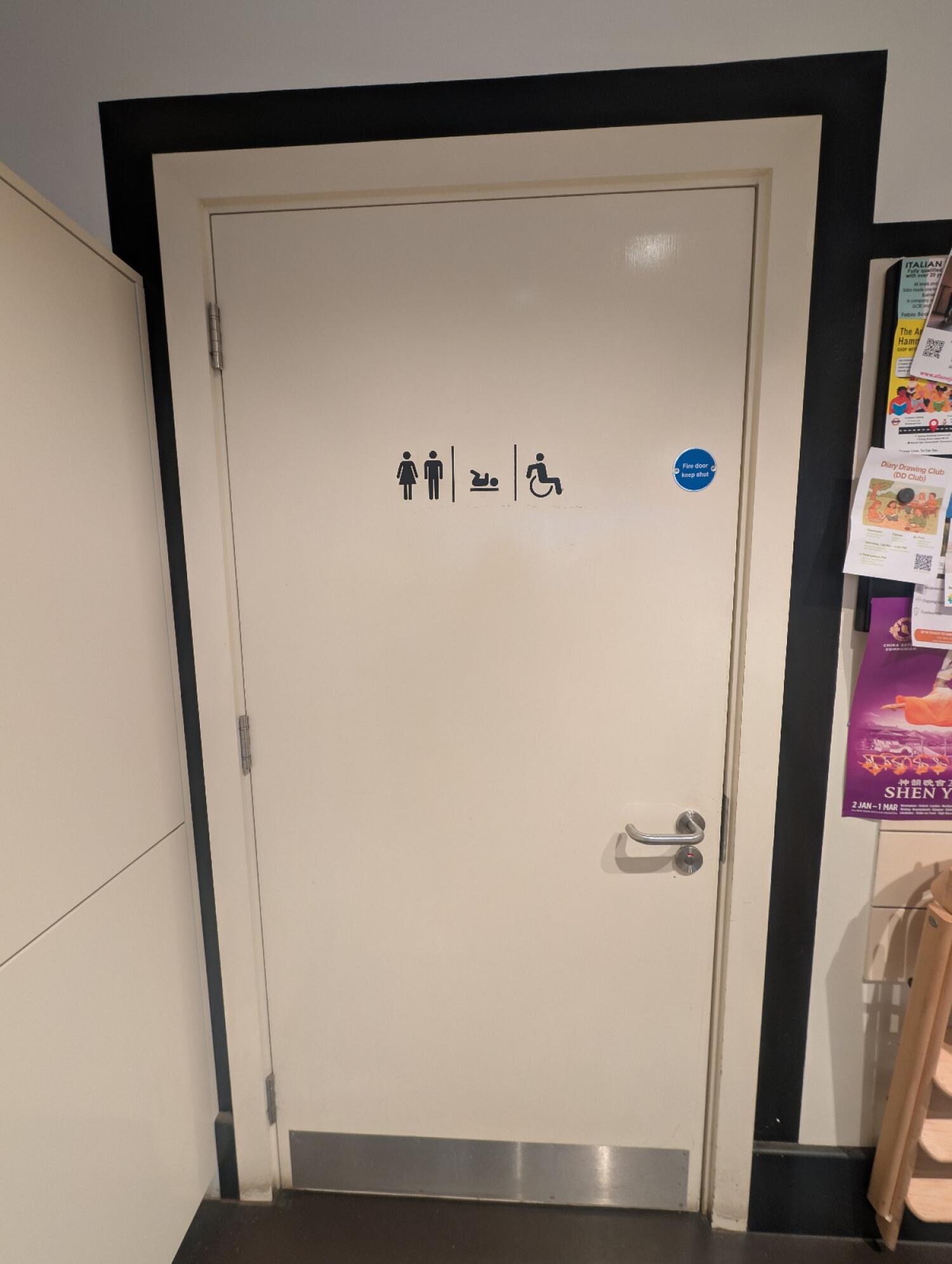 From left of staff area facing straight. Black frame white door in front. Silver handle on right. Pull to open.