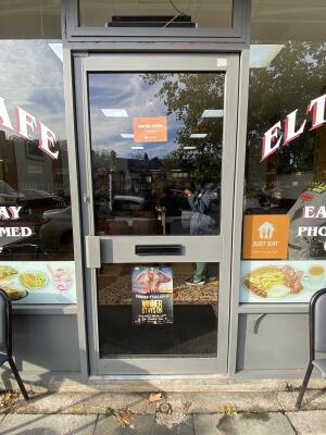Grey framed glass door. Push from left to open.