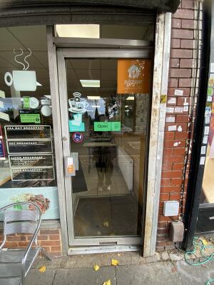 Silver framed glass door. Push from left to open.