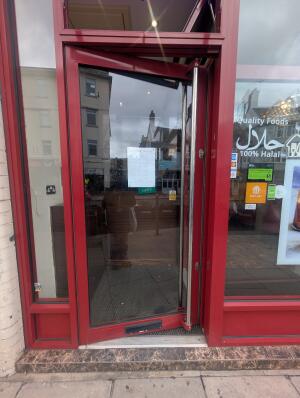 Red frame glass doors. Silver handle on right. Push to open.