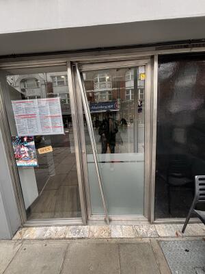 Glass door with metal frame ahead. Push from left to open.