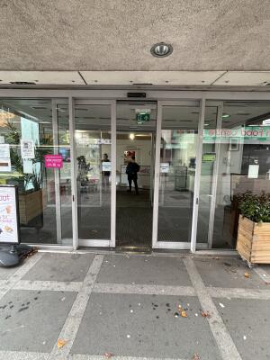 Glass doors with white frame ahead. Doors open automatically from center.
