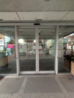 White frame automatic glass doors in front.