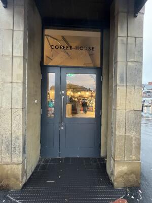 Wooden grey door with handle on the left. Pull to open.