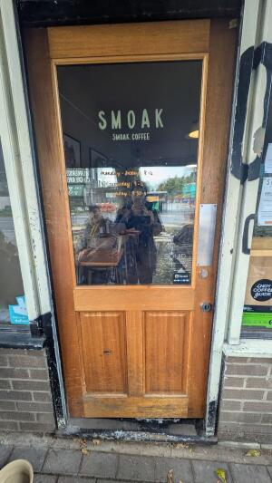 Glass door with wooden frame. Push handle on right to open