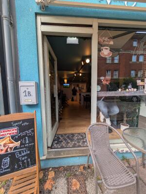 Glass door with white, wooden frame. Push handle from right to open.