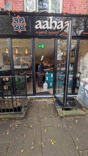 Glass door with black frame. Pull handle on left to open