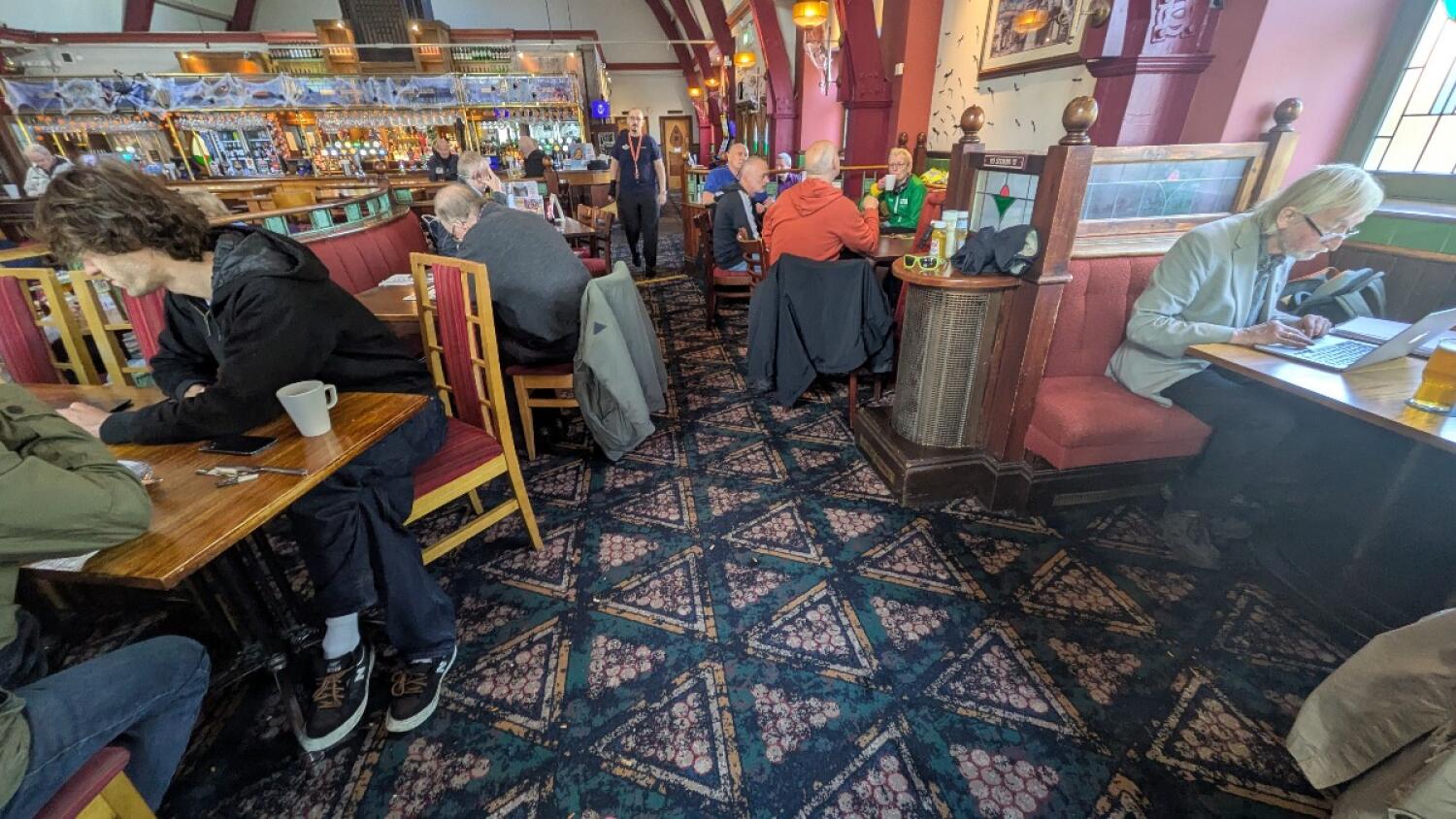 From ramp facing left. Tables and chairs to left. Half booths, tables and chairs along back left. Booths along right