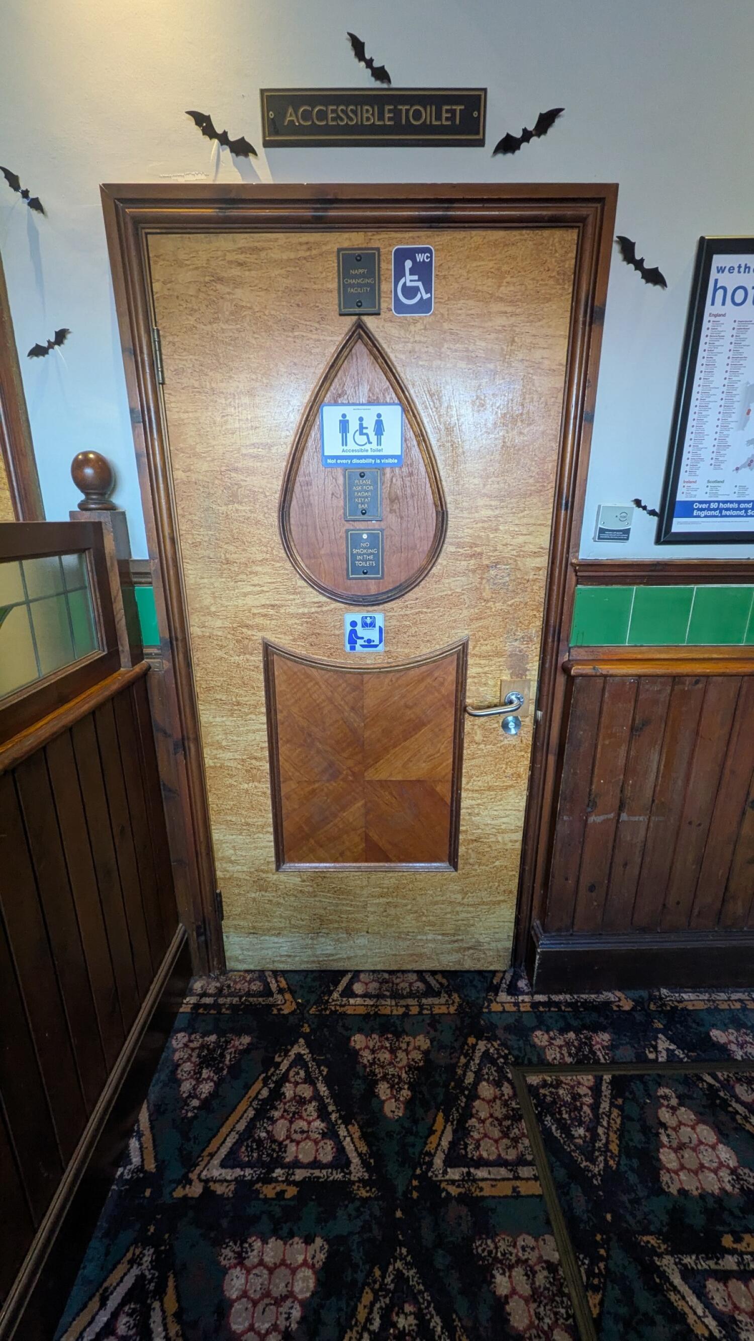 From right of additional back area facing right. Wooden toilet door ahead. Pull handle on right to open