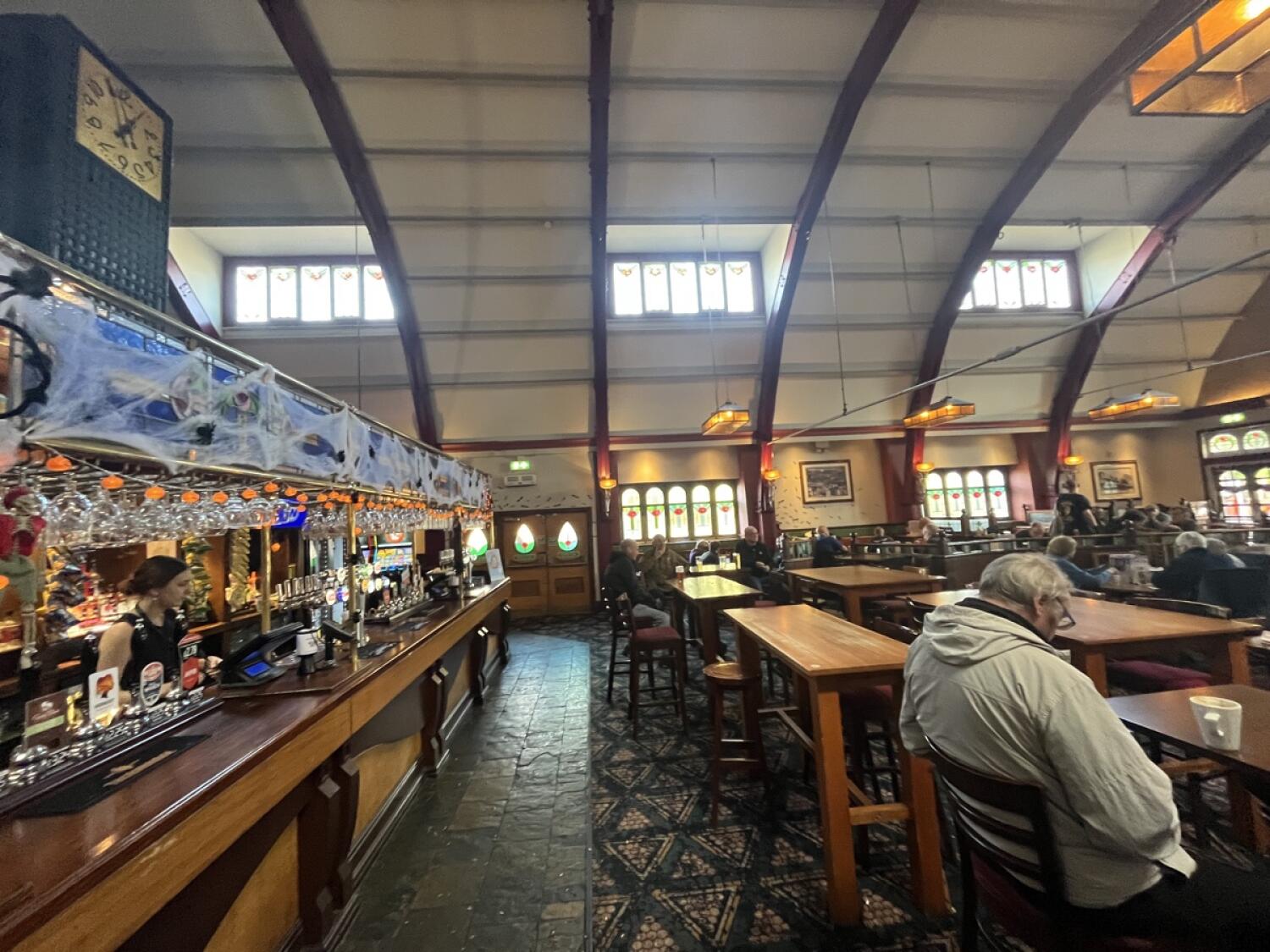From counter facing right. Counter along the left. Open path in centre. Stools and tables spread on right side.