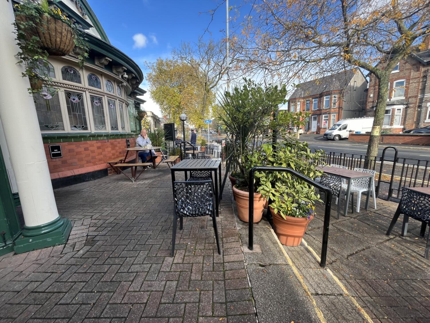From door facing right. Picnic table, tables and chairs ahead.
