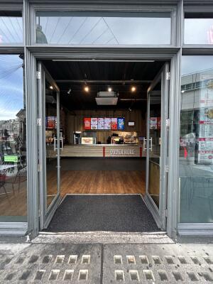 Glass doors with grey frames ahead. Push from center to open.