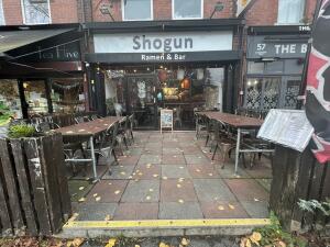 From street facing venue. Opening at fence followed by pathway.