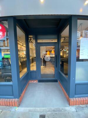 Blue frame archway in front. Blue frame glass doors at back. Black handle on right. Pull to open.
