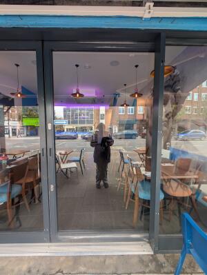Glass door with grey frames ahead. Slide from left to open.