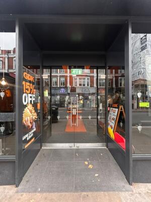 Grey frame archway in front. Full glass doors at back. Silver metal handles in center. Pull to open.