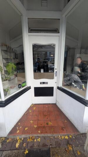 White wood-framed glass door. Pull from handle on right to open.