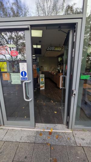 Glass doors with metal frame. Push handles in center to open